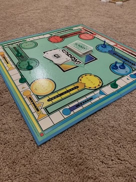 A "Sorry!" board game set up on a beige carpet, showcasing its colorful board and pawns. This classic game is a great choice for preschoolers to practice counting, turn-taking, and color recognition while having fun with family.