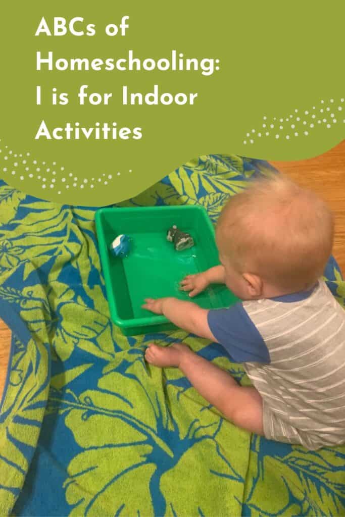 Pinterest image featuring a young toddler sitting on a tropical-patterned towel indoors, playing with water in a green sensory bin. Two floating toy animals are visible in the water as the child splashes with both hands. The top of the image includes text that reads, “ABCs of Homeschooling: I is for Indoor Activities.” This pin highlights simple and engaging indoor activities for toddlers and preschoolers, perfect for homeschool routines, sensory play, or rainy day fun.